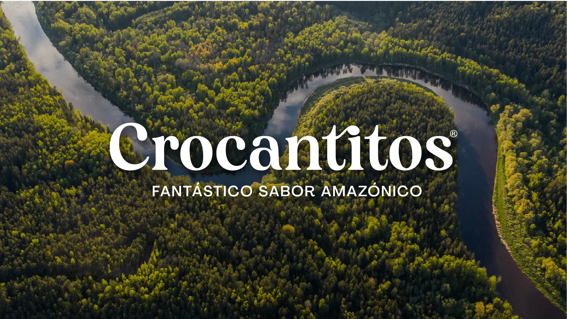 Vista aérea de un río serpenteante en la selva amazónica con el logotipo de Crocantitos y el eslogan Fantástico Sabor Amazónico por BSM.